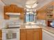 Efficient kitchen with white appliances and natural wood cabinets at 8600 E Broadway Rd # 88, Mesa, AZ 85208