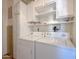Bright laundry room with white appliances, ample storage cabinets, and shelving at 8600 E Broadway Rd # 88, Mesa, AZ 85208