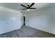 Bedroom with neutral carpet, fan, closet doors, and bathroom entrance at 907 E Broadmor Dr, Tempe, AZ 85282