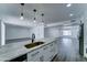 Modern kitchen with stainless steel appliances, granite countertops, and stylish lighting open to living space at 907 E Broadmor Dr, Tempe, AZ 85282