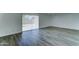 Bright living area featuring gray wood flooring and neutral paint, with backyard access at 907 E Broadmor Dr, Tempe, AZ 85282