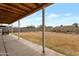 Covered backyard patio with a view of the large, fenced-in yard with sparse desert landscaping at 9157 W Gary Rd, Peoria, AZ 85345