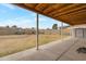 Covered backyard patio with a view of the large, fenced-in yard and desert landscaping at 9157 W Gary Rd, Peoria, AZ 85345