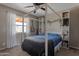 Bright bedroom with a four-poster bed, built-in shelves, and large window to the patio area at 9157 W Gary Rd, Peoria, AZ 85345