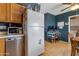 Kitchen view showcases stainless steel dishwasher, white refrigerator, and a desk area for office work at 9157 W Gary Rd, Peoria, AZ 85345