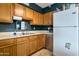Well-lit kitchen featuring wooden cabinets, stainless steel sink, modern appliances, and a refrigerator at 9157 W Gary Rd, Peoria, AZ 85345