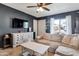 Stylish living room with a ceiling fan, dark wall, modern furniture, and plenty of natural light at 9157 W Gary Rd, Peoria, AZ 85345