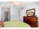 Bedroom with light grey walls, a ceiling fan, and a wood dresser with a mirror and television at 9450 E Becker Ln # 1036, Scottsdale, AZ 85260