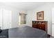Bedroom with a window, dark wood dresser, and grey bedding on the made bed at 9450 E Becker Ln # 1036, Scottsdale, AZ 85260