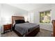 Bedroom with a dark wood bed frame, a window offering natural light, and dark grey bedding at 9450 E Becker Ln # 1036, Scottsdale, AZ 85260