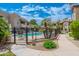 Inviting community pool area featuring a black fence, chairs, and lush landscaping on a sunny day at 9450 E Becker Ln # 1036, Scottsdale, AZ 85260