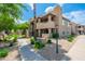 Beautiful condo building with lush greenery, sidewalk, and mature trees along with a well maintained landscape at 9450 E Becker Ln # 1036, Scottsdale, AZ 85260