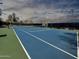 View of a vibrant blue tennis court with crisp white lines, set against a cloudy sky at 9450 E Becker Ln # 1036, Scottsdale, AZ 85260