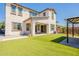 Home's backyard with artificial turf, covered patio, and fire pit seating area at 98 N Bay Dr, Gilbert, AZ 85233