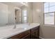 Bathroom boasts dual sinks with dark wood cabinetry, a large mirror, and natural light at 98 N Bay Dr, Gilbert, AZ 85233