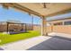 Covered patio with ceiling fan overlooks the landscaped backyard with fire pit seating area at 98 N Bay Dr, Gilbert, AZ 85233