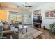 Inviting living room with modern ceiling fan, wood floors, and sliding doors to the outdoor pool at 9816 E Stone Circle E Ln, Gold Canyon, AZ 85118