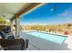 Relaxing covered patio overlooking a sparkling pool, offering a serene outdoor living space with beautiful desert views at 9816 E Stone Circle E Ln, Gold Canyon, AZ 85118