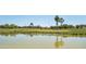 Golf course and water feature with clear reflections and golfers practicing at 992 S Roanoke St, Gilbert, AZ 85296