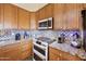Close up of kitchen with stainless appliances, granite counters, tile backsplash and wood cabinets at 992 S Roanoke St, Gilbert, AZ 85296