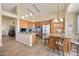 Bright kitchen features wood cabinets, granite counters, tile backsplash, island and pendant lighting at 992 S Roanoke St, Gilbert, AZ 85296