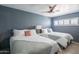 Comfortable bedroom featuring two beds, ceiling fan, and serene blue walls at 10007 N 30Th Pl, Phoenix, AZ 85028