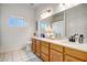 Double-sink bathroom with wood cabinets, white countertops, and neutral decor at 10215 W Missouri Ave, Glendale, AZ 85307