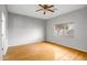 Bedroom with hardwood floors, ceiling fan, and window with blinds for natural light at 10215 W Missouri Ave, Glendale, AZ 85307