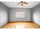 Sunlit bedroom featuring wood flooring, a ceiling fan, and a window with blinds for privacy at 10215 W Missouri Ave, Glendale, AZ 85307