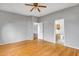 Bright bedroom featuring a ceiling fan and an ensuite bathroom with wood floors and neutral gray walls at 10215 W Missouri Ave, Glendale, AZ 85307