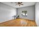 Bright bedroom with hardwood floors, ceiling fan, and a view of mature landscaping outside at 10215 W Missouri Ave, Glendale, AZ 85307