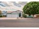 Charming single-story home boasts a three-car garage, desert landscaping and black front door at 10215 W Missouri Ave, Glendale, AZ 85307