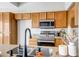 Modern kitchen boasts stainless steel appliances, granite countertops, and natural wood cabinets at 10215 W Missouri Ave, Glendale, AZ 85307
