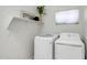 Modern laundry room with new white washer and dryer plus a storage shelf at 10215 W Missouri Ave, Glendale, AZ 85307