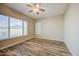 This bedroom features a ceiling fan, a window with blinds, and wood-look floors at 10465 E Dutchmans Trl, Gold Canyon, AZ 85118