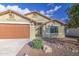 Close-up of a home's facade with a brown garage door and desert landscaping at 10465 E Dutchmans Trl, Gold Canyon, AZ 85118