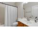 Cozy bathroom with a shower-tub combo, white shower curtain, and wood vanity cabinet at 10758 E Lobo Ave, Mesa, AZ 85209