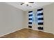 Bright bedroom with wood flooring, neutral walls, and a window with striped curtains at 10758 E Lobo Ave, Mesa, AZ 85209