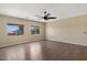 An expansive bedroom with wood floors, fan and two windows that let in natural light at 10758 E Lobo Ave, Mesa, AZ 85209
