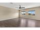An expansive bedroom with wood floors, fan and two windows that let in natural light at 10758 E Lobo Ave, Mesa, AZ 85209
