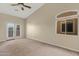 A spacious bedroom featuring carpet, a fan and sliding glass doors to the exterior at 10758 E Lobo Ave, Mesa, AZ 85209