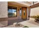 Inviting front porch with a decorative wood door and well-maintained landscaping at 10758 E Lobo Ave, Mesa, AZ 85209