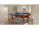 This game room features a wooden pool table on a patterned rug and natural light from a window at 10758 E Lobo Ave, Mesa, AZ 85209