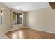Empty living room with wood floors, base moulding, and a large window at 10758 E Lobo Ave, Mesa, AZ 85209