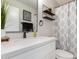 Modern bathroom featuring quartz counters, a black faucet, and a decorative shower curtain at 11221 W Devonshire Ave, Phoenix, AZ 85037