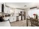 Modern kitchen offers stainless steel appliances, white cabinets, and a view of the dining area at 11221 W Devonshire Ave, Phoenix, AZ 85037