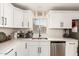 Bright kitchen features white cabinets, stainless steel appliances, and modern fixtures at 11221 W Devonshire Ave, Phoenix, AZ 85037