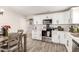 Well-lit kitchen with stainless steel appliances, white cabinets, and a wood-look tile floor at 11221 W Devonshire Ave, Phoenix, AZ 85037