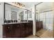 Bathroom with double sink vanity, updated lighting, and large mirror at 11341 W Barbara Ave, Peoria, AZ 85345