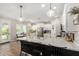 Bright, white kitchen with stainless steel appliances, a large island with seating, and modern pendant lighting at 11526 E Shepperd Ave, Mesa, AZ 85212